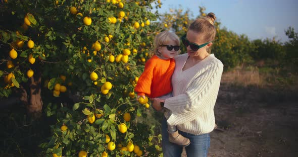 Young Woman Holding Little Daughter in Her Arms