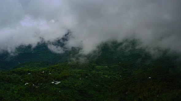 aerial of rain clouds moving fast over a green jungle in Bali Indonesia
