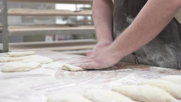 Baker Kneading Dough in a Bakery