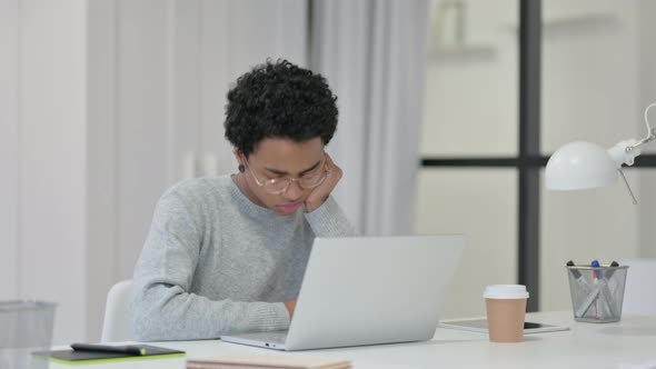 Young African Woman with Laptop Taking Nap at Work 