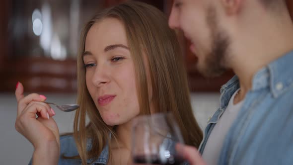 Closeup Face of Cheerful Young Beautiful Caucasian Woman Enjoying Sweet Dessert Looking at Man