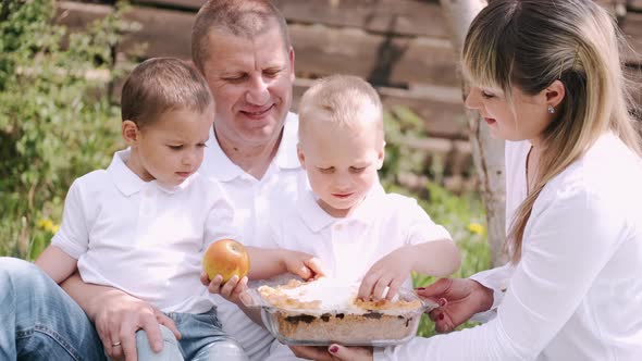 Portrait of Parents with Two Little Sons Having Picnic