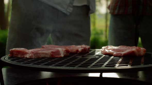 Chef Putting Meat Slices on Grate Outside