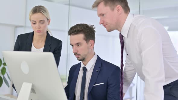 Ambitious Business Team Working Together on Desktop