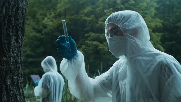 Chemists Wearing Ppe Suits Taking Sample of Tree Bark for Researching Toxicity Testing Typing in