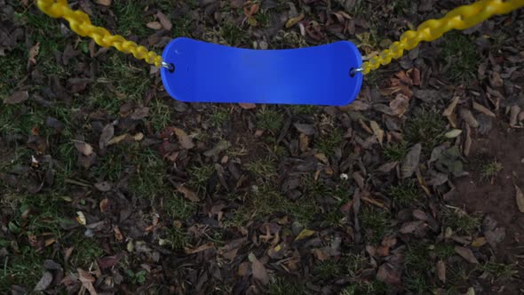 Blue swing hanging from yellow chain