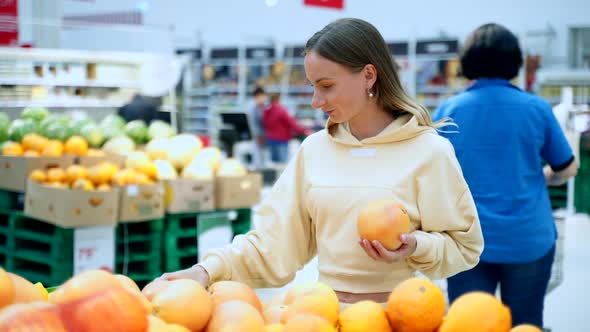 Woman Buying Fresh Citrus Fruits - Grapefruits at Supermarket. Health Care Concept