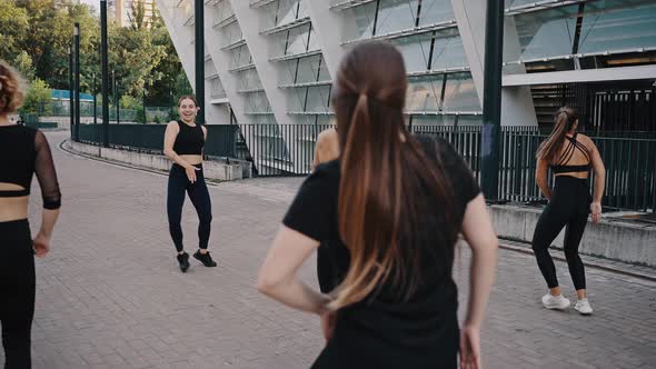 Group of Girls are Dancing Outdoor on a City Street in a Sport Wearing