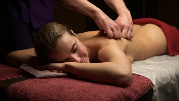 Young beautiful woman enjoying relaxing massage in the salon of masseur