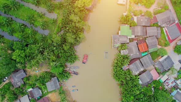 An aerial view over a fishing village by a canal in the countryside