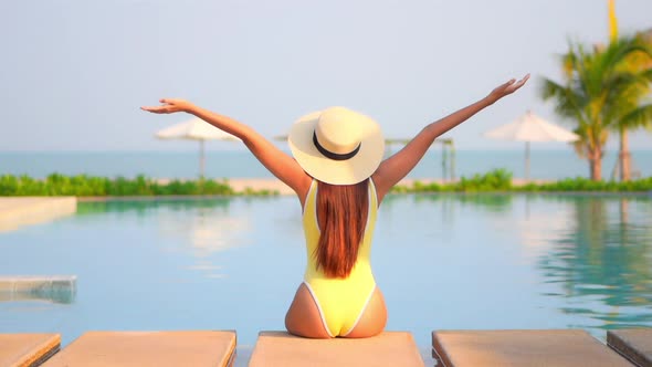 Young asian woman enjoy around outdoor swimming pool for leisure