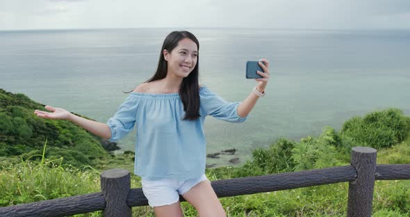 Woman take selfie on mobile phone in ishigaki island landmark