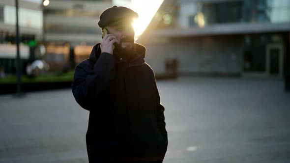 Handsome Man is Calling By Cell Phone on City Street in Sunny Morning