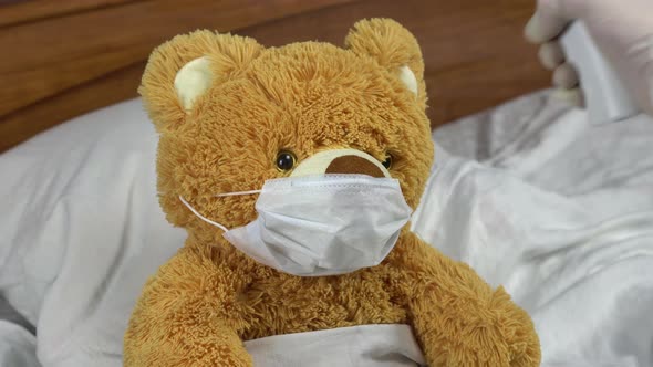 A Teddy Bear Is Measured with an Infrared Thermometer. The Doctor Makes a Temperature Measurement