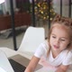 Little Girl Using Tablet Computer Sitting at Table - VideoHive Item for Sale