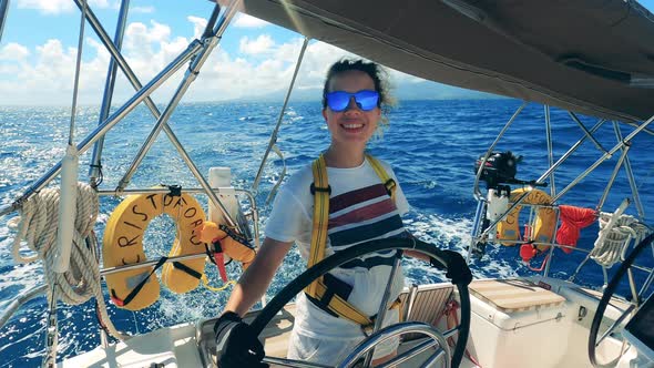 Happy Woman Drives a Yacht on Ocean.