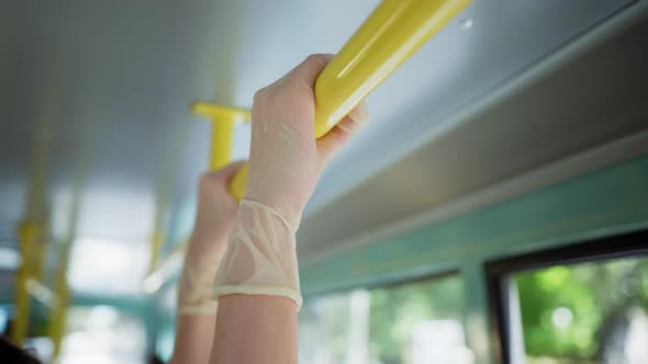 Female Passenger on City Bus Wearing Medical Glove To Protect Against Virus and Infection Holds on