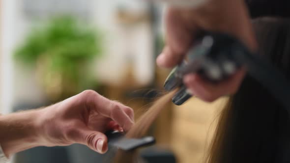 Handheld view of hairdresser using straightener. Shot with RED helium camera in 8K