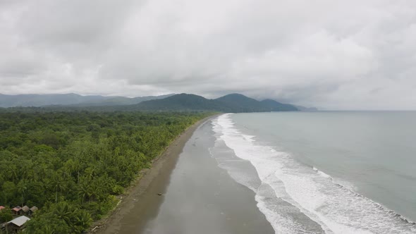 Aerial shot of a blacksand beach during a cloudy day on the Pacific Coast, Colombia.