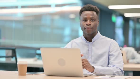 African Businessman with Laptop Shaking Head As Yes Sign