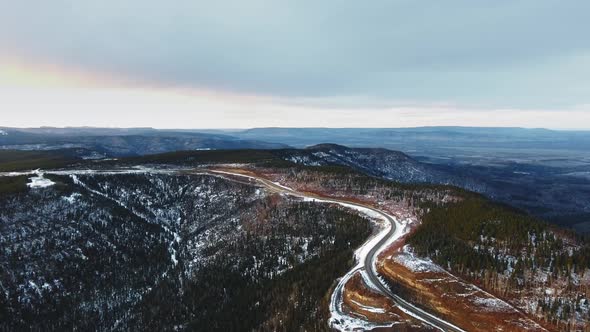 Drone camera shoots the road at the top of a mountain covered with snow in Alberta, Canada