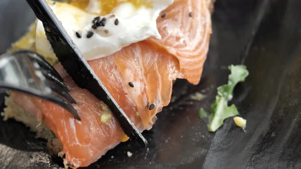 Person Hands Cut Bread with Salmon Egg with Knife and Fork
