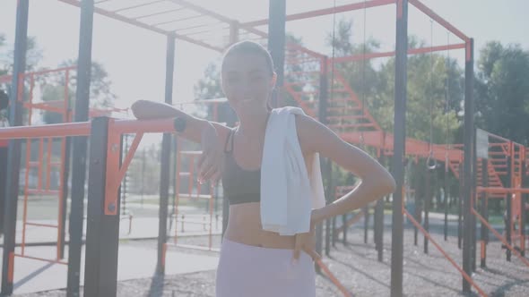 African Athletic Middle Aged with White Terry Towel Over Her Shoulders Resting After Workout on