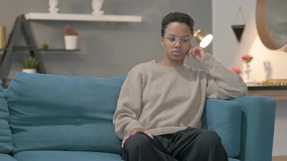 African Woman Sitting on Sofa Thinking