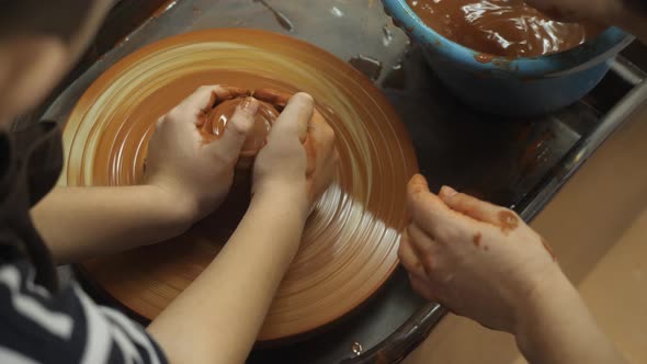 A Potter Shows How To Properly Hold a Piece of Clay on a Potter's Wheel