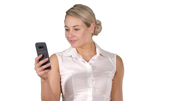 Young girl reading from mobile phone screen on white background.