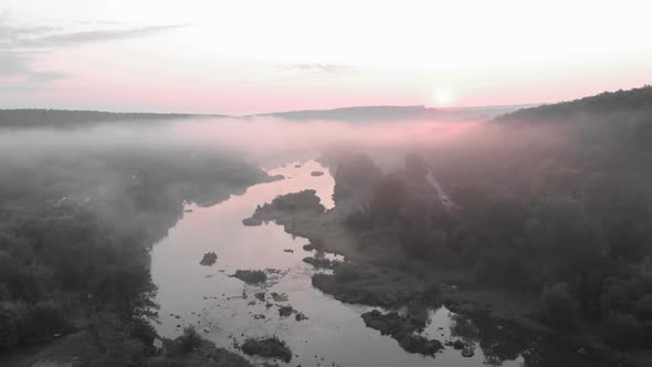 Beautiful foggy river and forest at sunrise