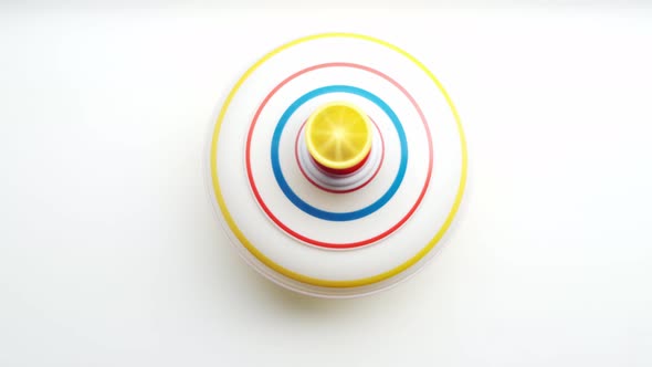 Untwisted whirligig, children toy spinning top spinning on white background.View from top.