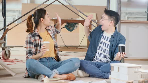 Cheerful asian couple hand rise up with successful and happiness renovating the house