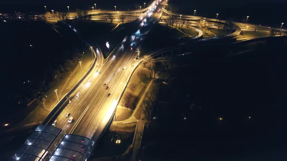 Illuminated road intersection at night. Aerial drone view.