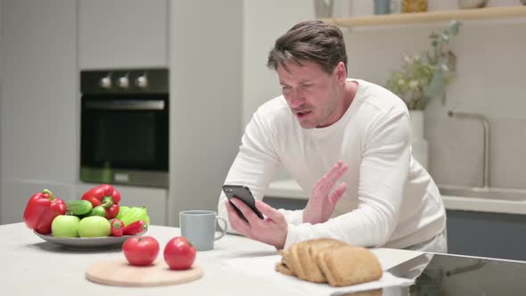 Man Doing Video Call on Smartphone in Kitchen