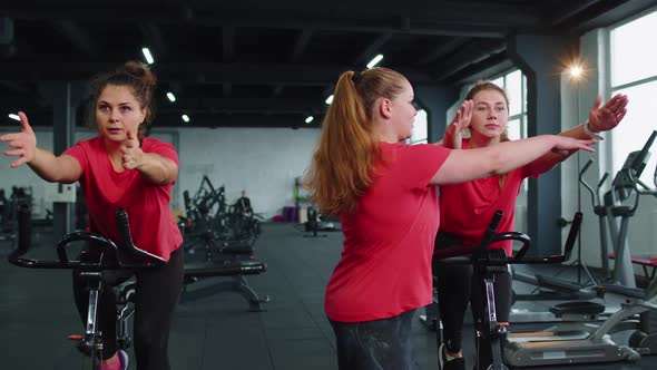 Group of Girls Performs Aerobic Training Workout Cardio Routine on Bike Simulators Cycle Training