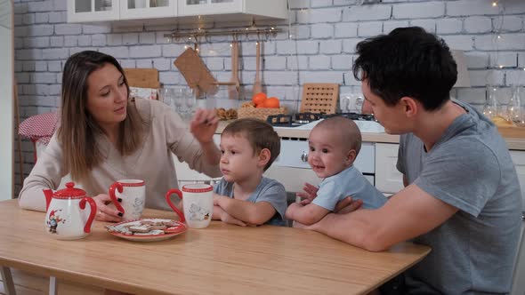 Family of Four Drinking Tea in the Kitchen