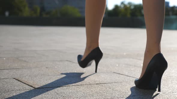 Female Legs in High Heels Shoes Walking in the Urban Street. Feet of Young Business Woman in High