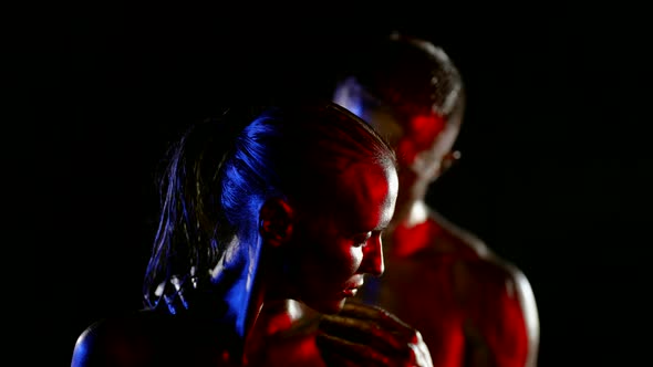Portrait of a Couple with Golden Metallic Skin on a Black Background