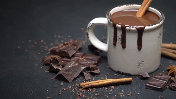 Cup of Hot Chocolate and Pieces of Chocolate on Dark Concrete Background