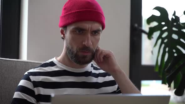 Attentive bearded man working on a laptop