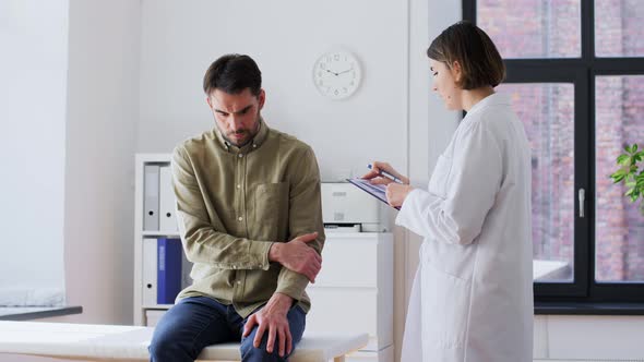 Man Patient Showing Sore Arm to Doctor at Hospital