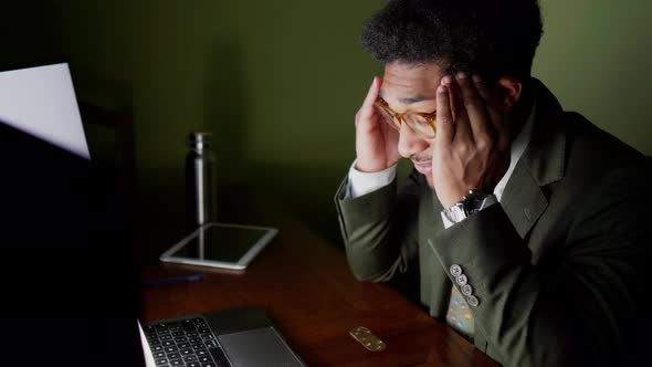 Stressed businessman touching head in office