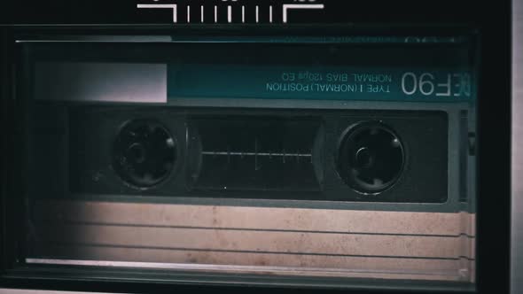 Audio Cassette Rotates in Deck of an Old Tape Recorder