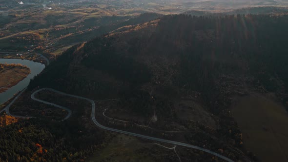 Stunning Cinematic Aerial View of Curved Serpentine Mountain Road Yellow Fall Woods on Mountain