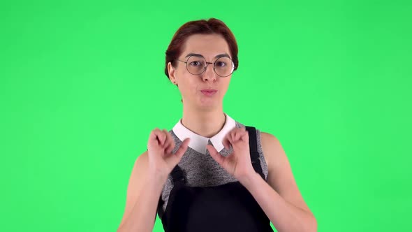 Portrait of Funny Girl in Round Glasses Is Blowing Kiss. Green Screen