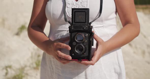 A Woman Holds a Camera in Her Hands