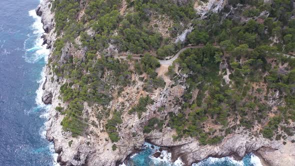 Natural and green cliffs of Mallorca. Hiking trails can be seen in the mountains and the ocean is al