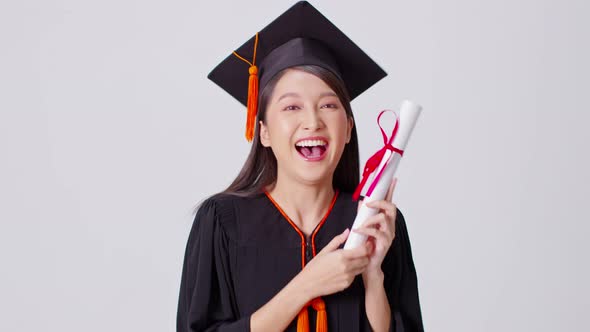 Beautiful Attractive Asian woman graduated in cap and gown smile