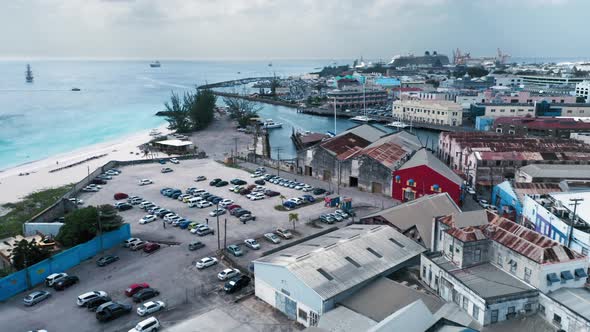 Aerial view of parking lot with cars, rooftops, a bay with yacht and ships in Bridgetown, Barbados